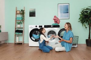 Frau und Tochter waschen freudig Wäsche