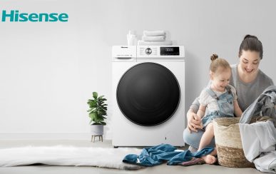 Frau macht glücklich die Wäsche mit Tochter neben Hisense Waschmaschine